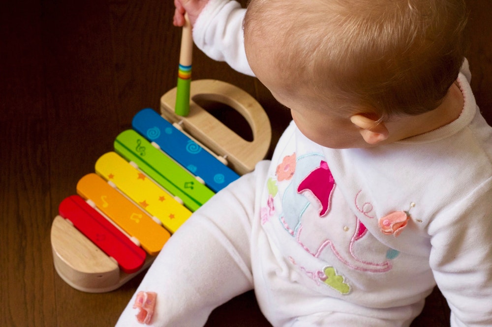Kleinkind mit buntem Glockenspiel