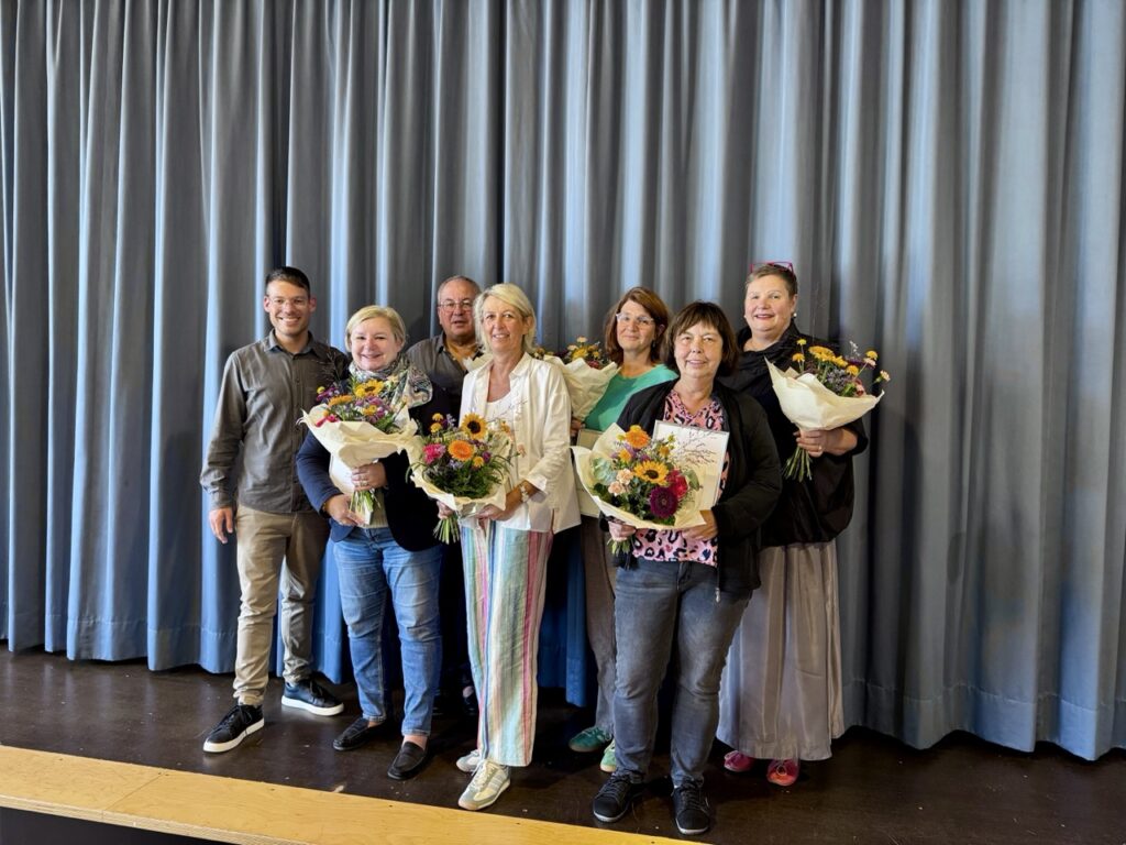 Eine Gruppe Lehrkräfte mit Blumensträußen und Schulleiter Nico Zipp