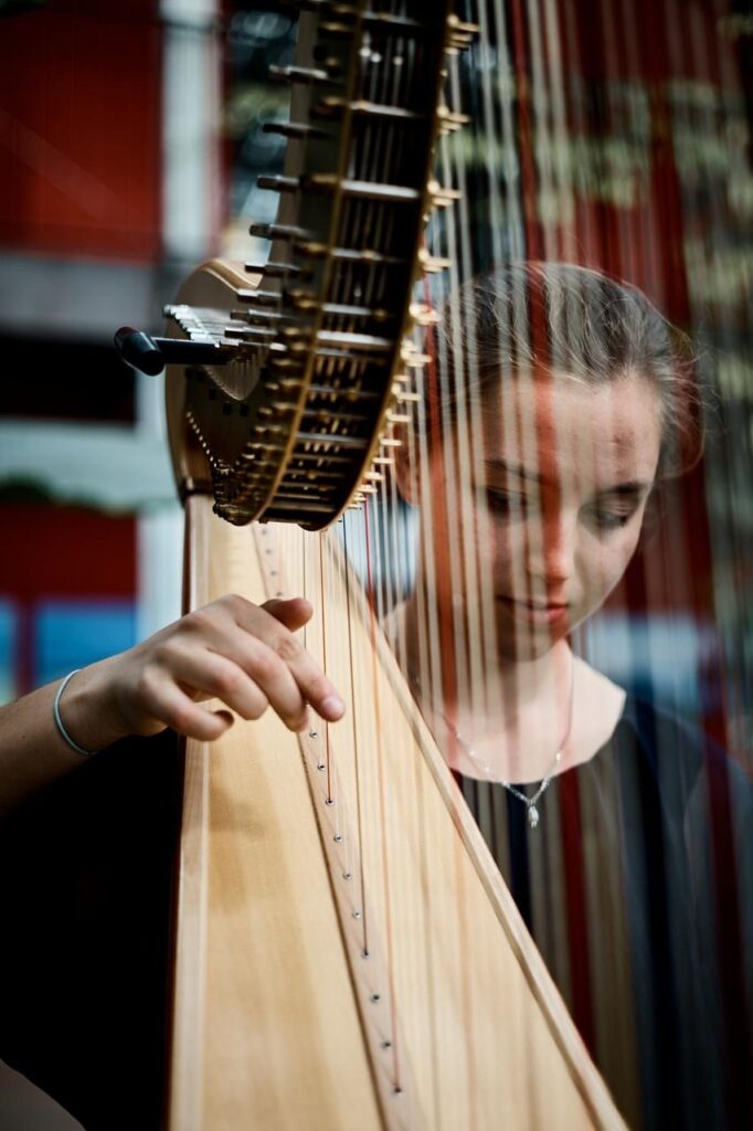 Junge Frau spielt auf ihrer Harfe
