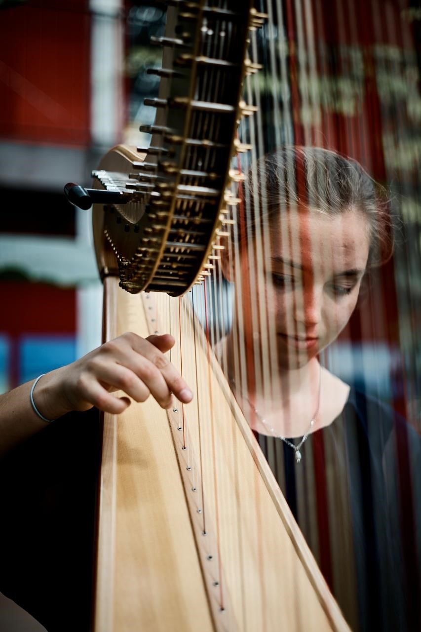 Junge Frau spielt auf ihrer Harfe