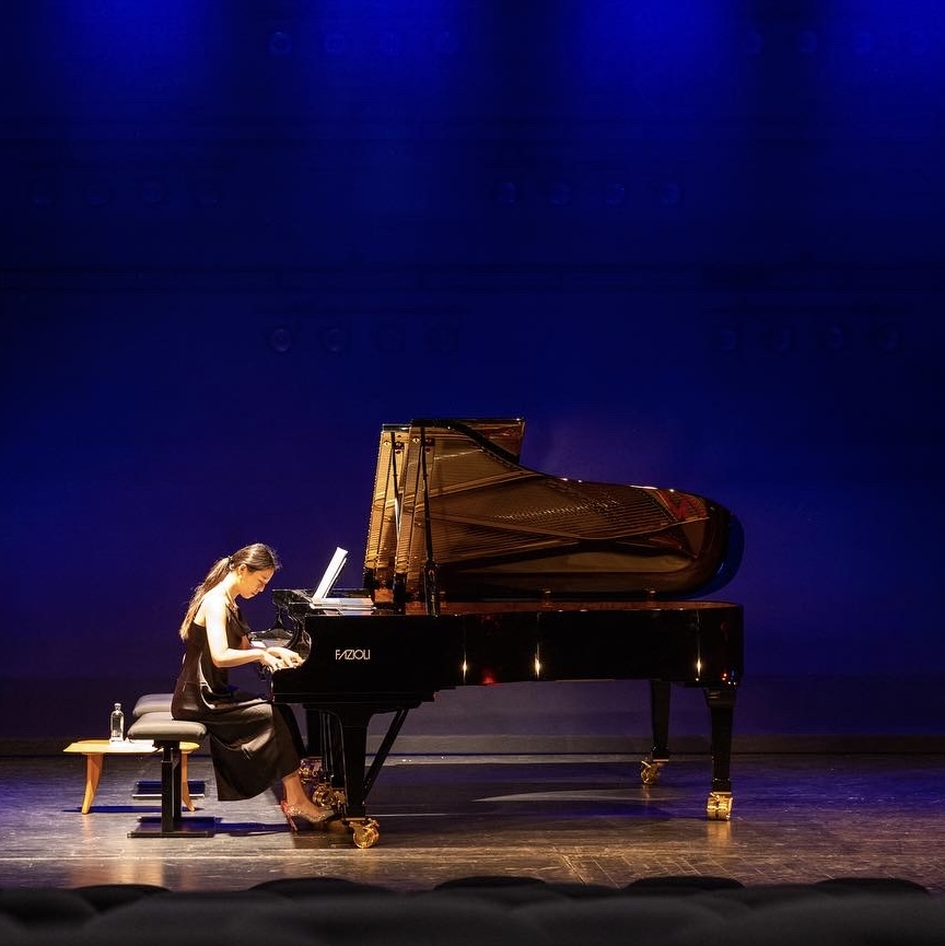 Pianistin auf Bühne an Fazioli Flügel